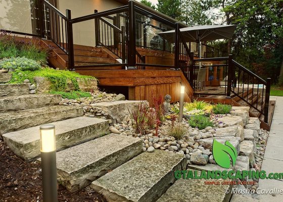 GTA-Landscaping-Alamosa-Dr.-Toronto-Stone-steps-Low-voltage-lights-Ipe-deck-Glass-railings-armor-stone-wall-paved-walkway